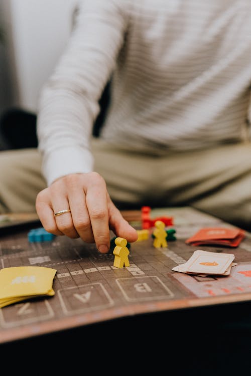 Close-up of a hand taking a counter from a game board — competitive strategy in action