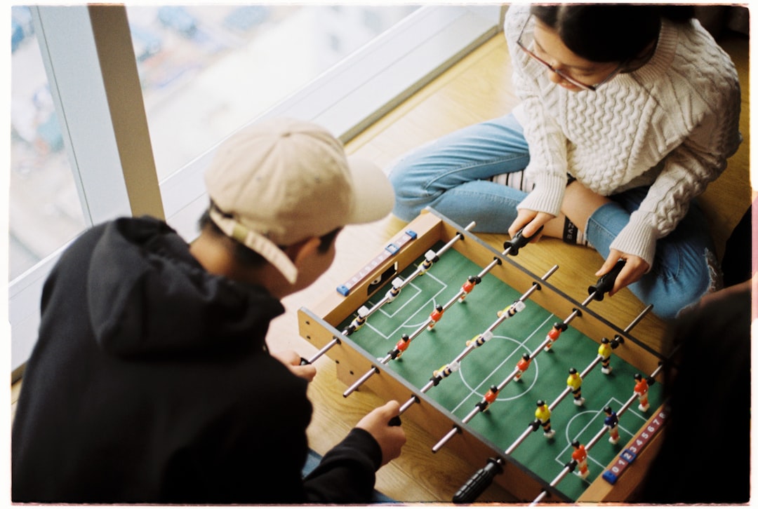 Young adults laughing together around a board game at a flat kitchen table