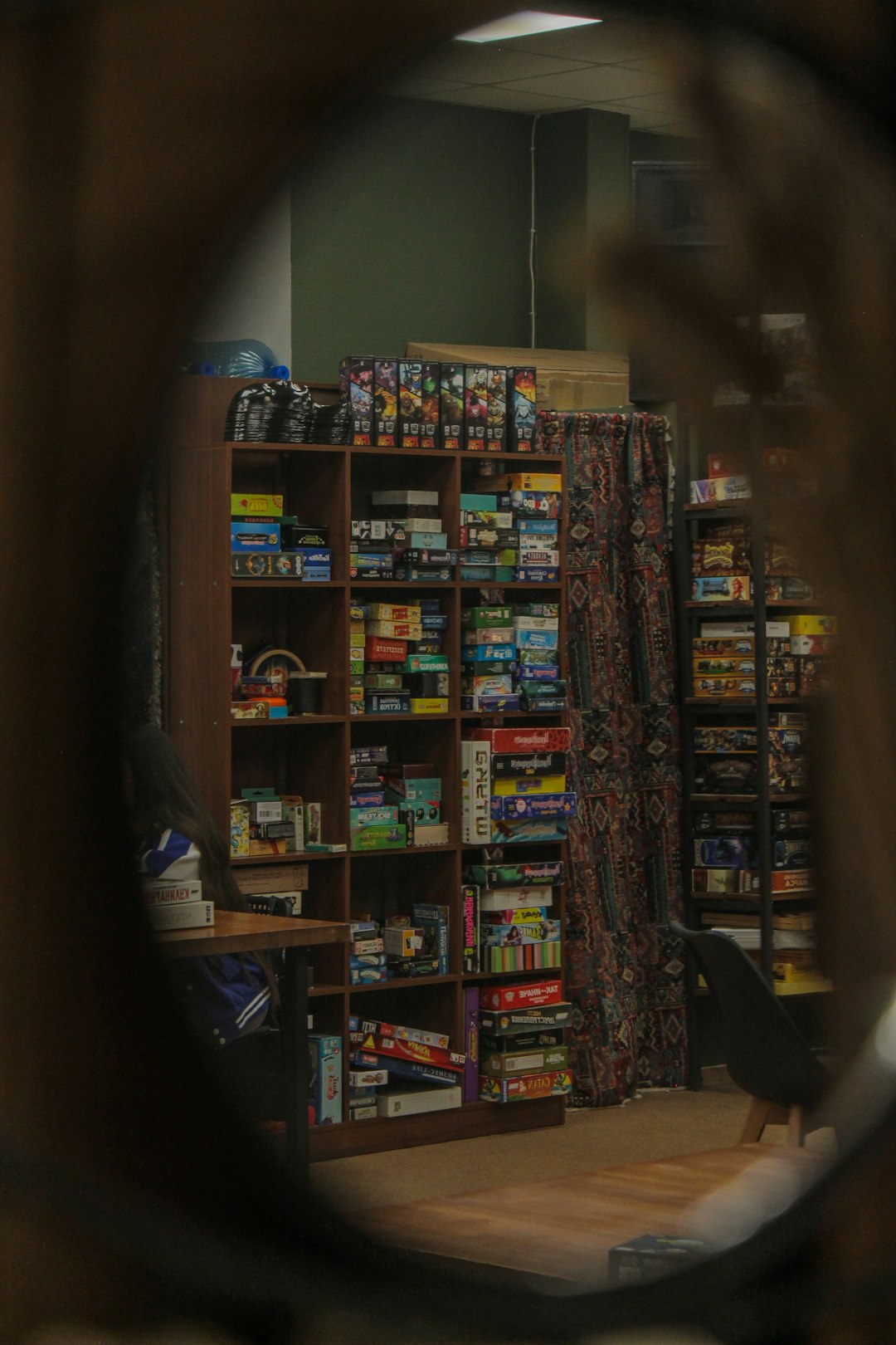 A well-organised shelf of board game boxes arranged neatly in a home