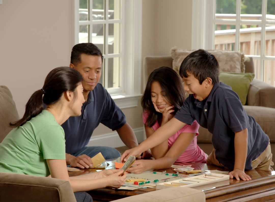 Family of four playing a board game together at a table
