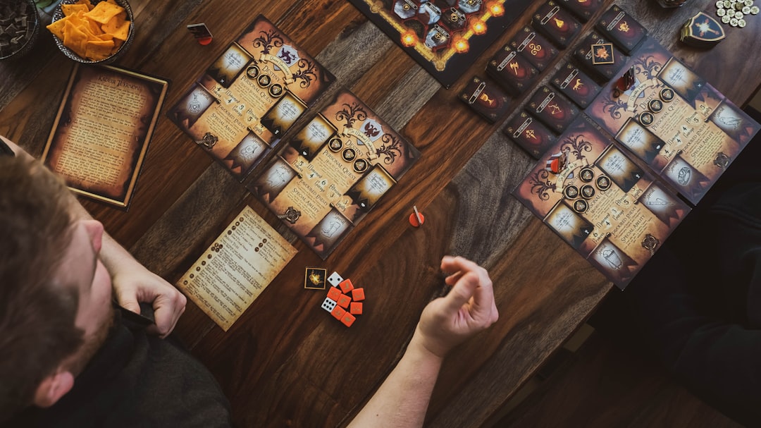 A single player leaning over a board game, arranging pieces alone at a table.