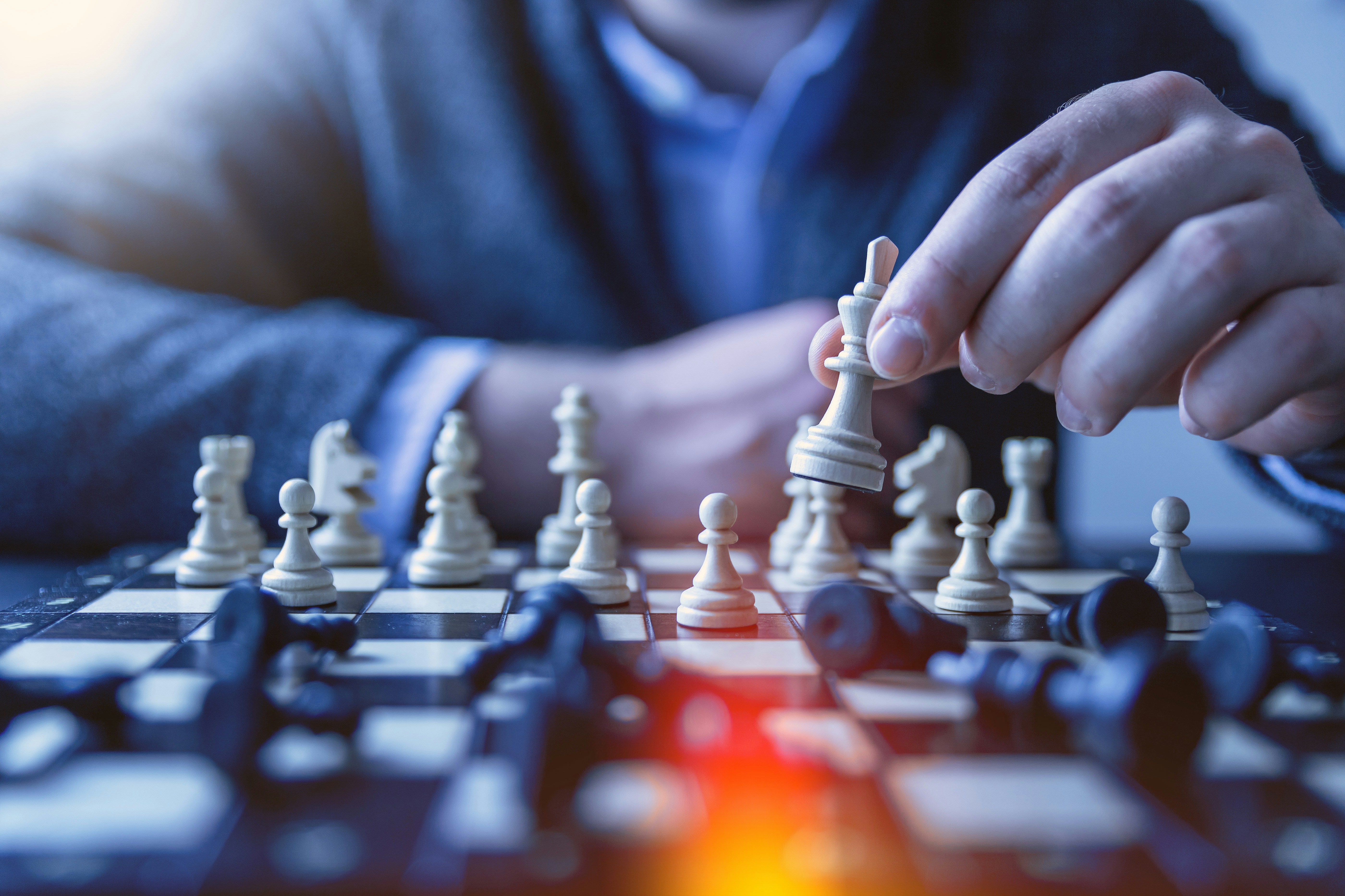 Two players in intense focus at game table analysing each other's moves and expressions
