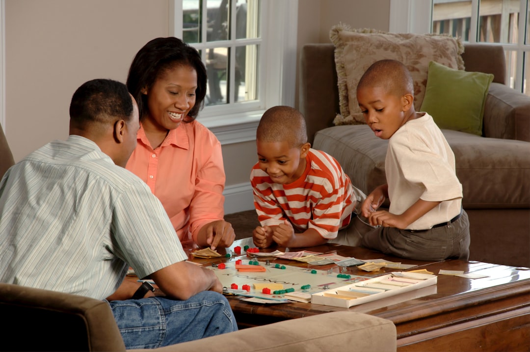 A family sitting around a coffee table playing board games at home in the evening