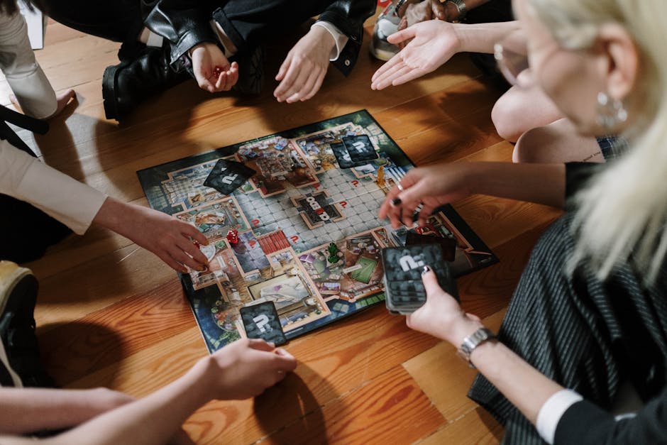 Five people gathered around a table playing a strategy board game together, laughing and fully engaged in competitive play