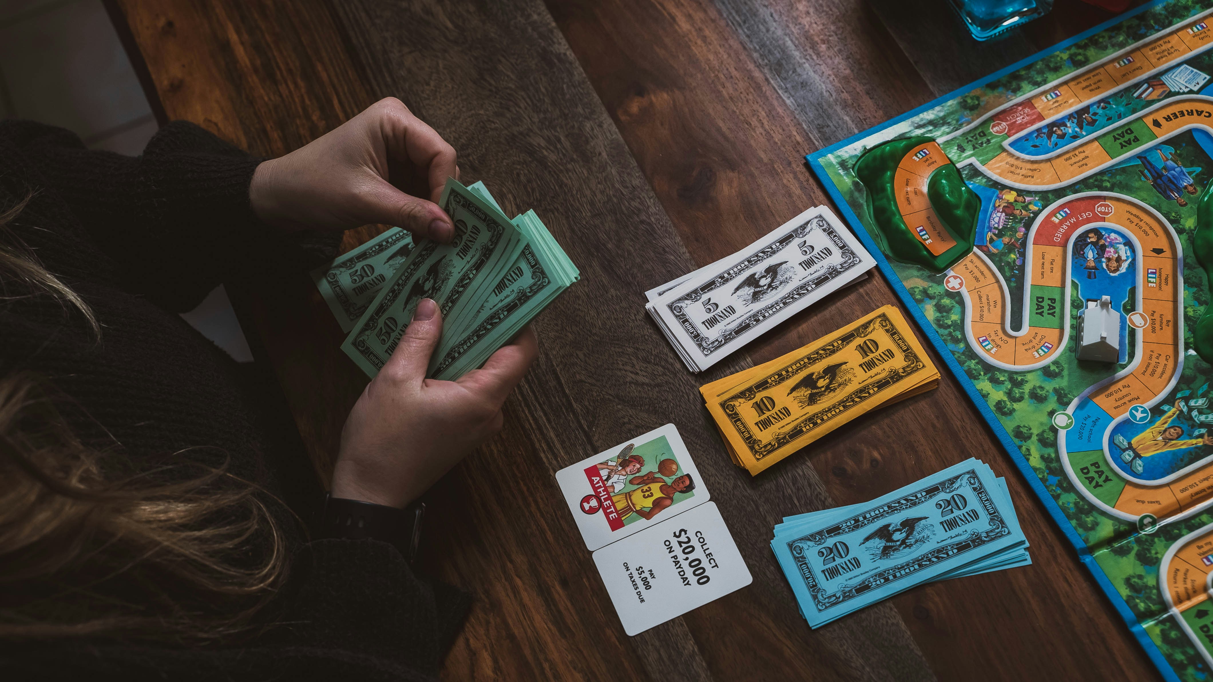 Children playing a board game with play money, learning financial concepts through gameplay