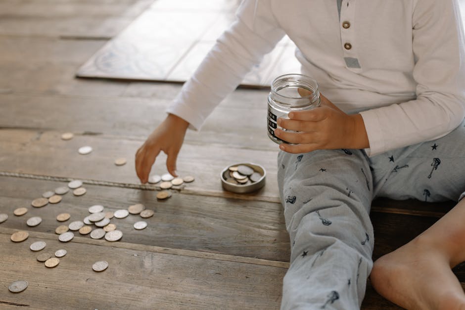 Child learning budgeting by saving coins in a jar