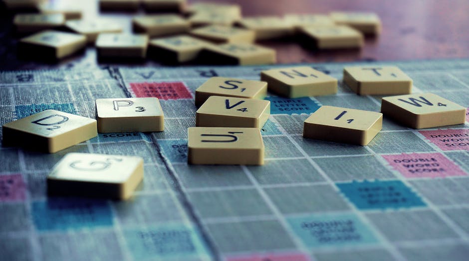 Close-up of Scrabble tiles scattered on the board, capturing leisure and word play.