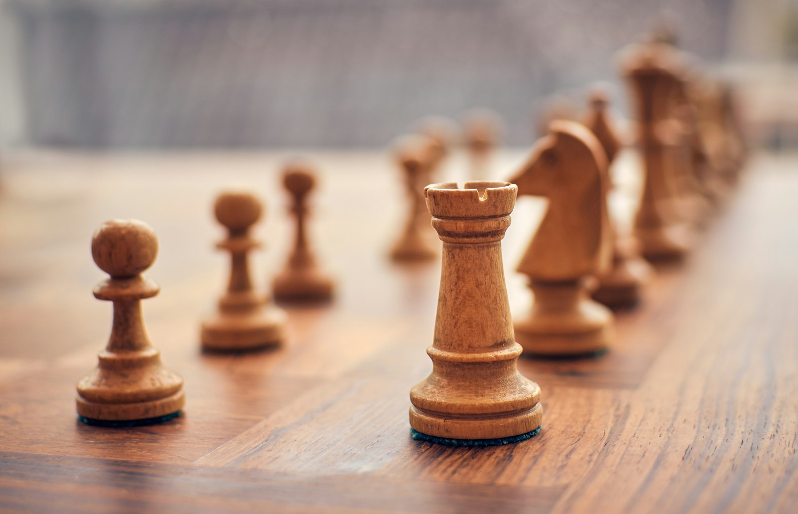 Wooden game pieces arranged on a table, evoking the classic era of economic board game design
