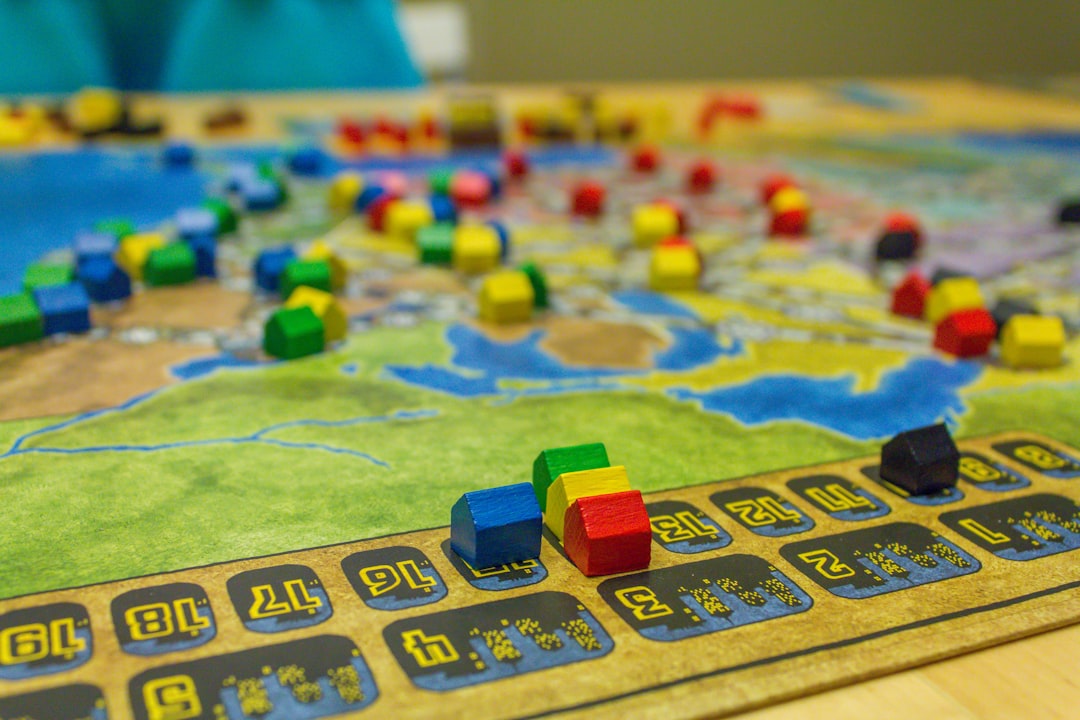 Colourful wooden game pieces arranged on a map-style board, representing route-building and territory strategy games