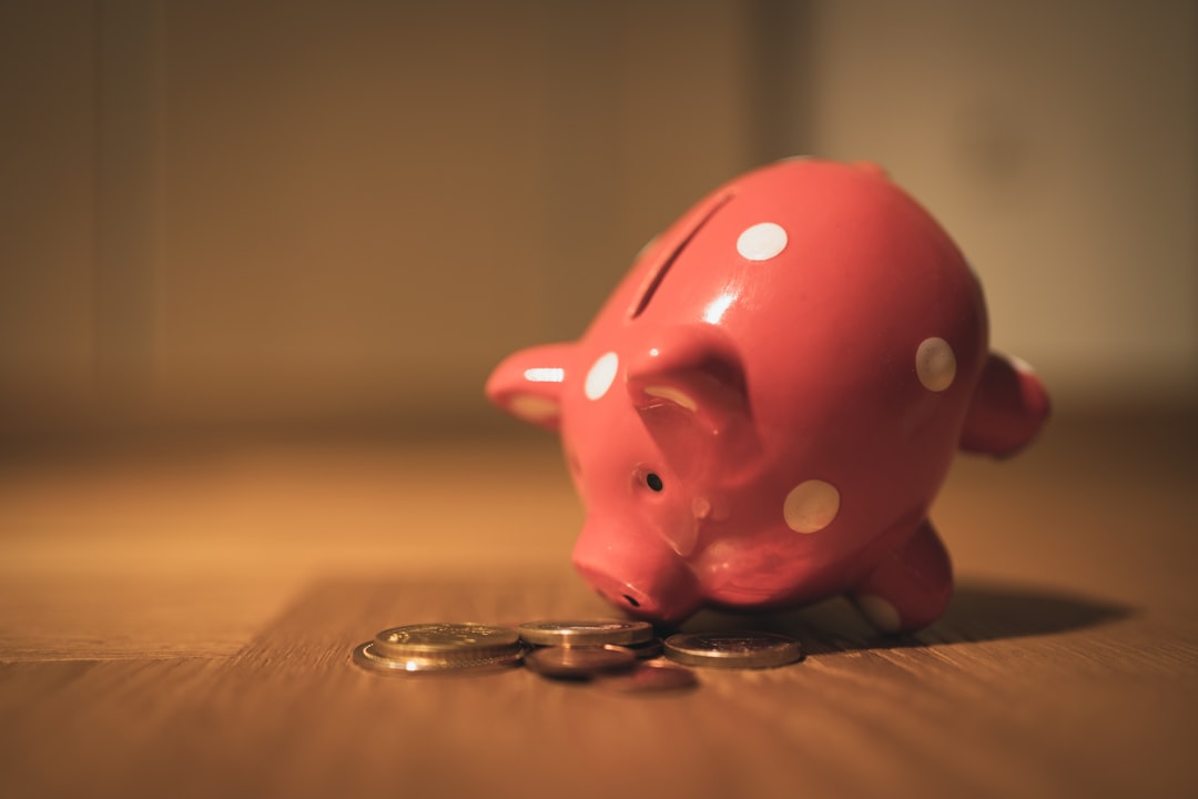 A pink piggy bank on a wooden table, symbolising a child's first steps in learning about money.